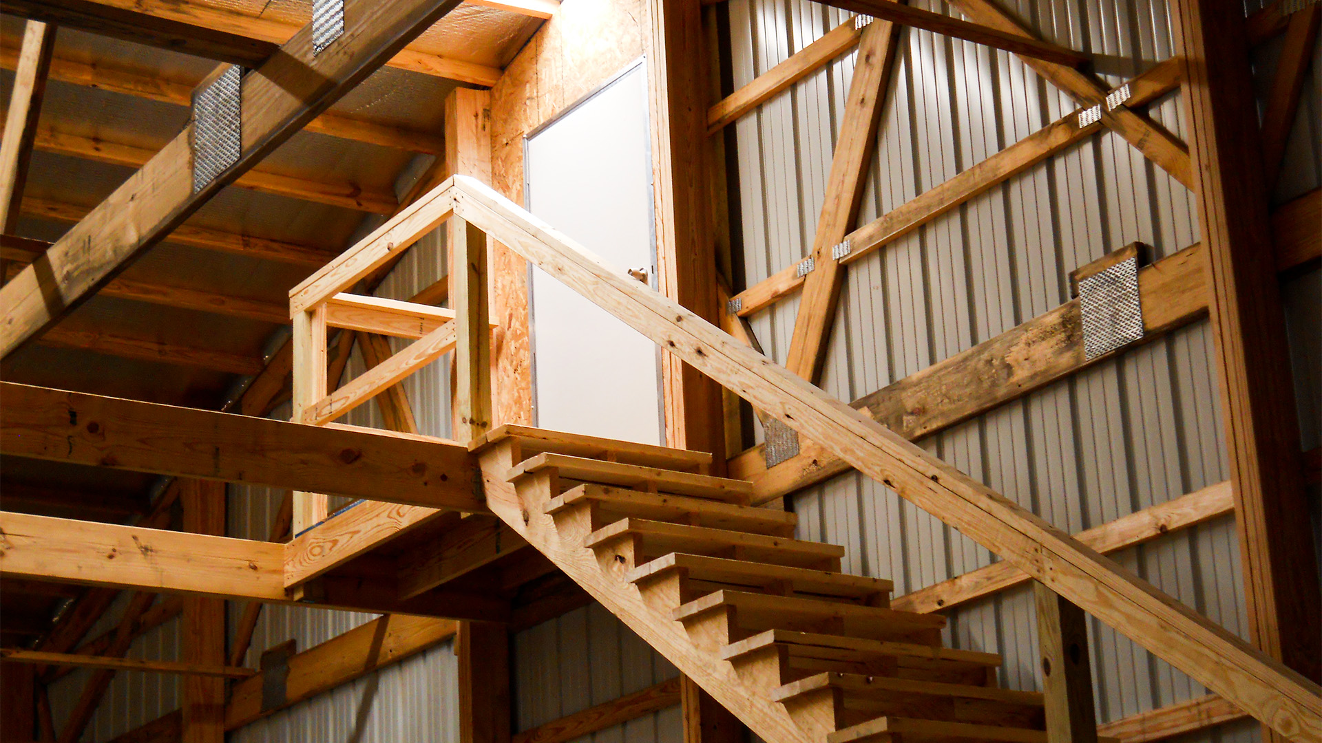 Interior of a metal structure with exposed post frames and staircase in Marion, Illinois