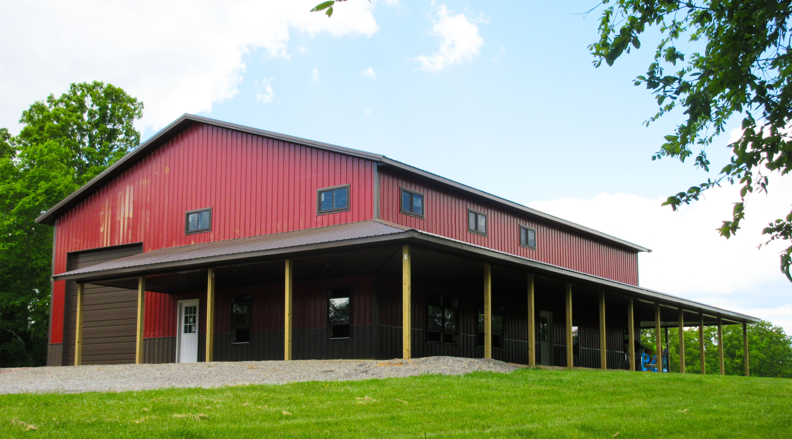 Red and black barn style home with wrap around porch in Marion, Illinois