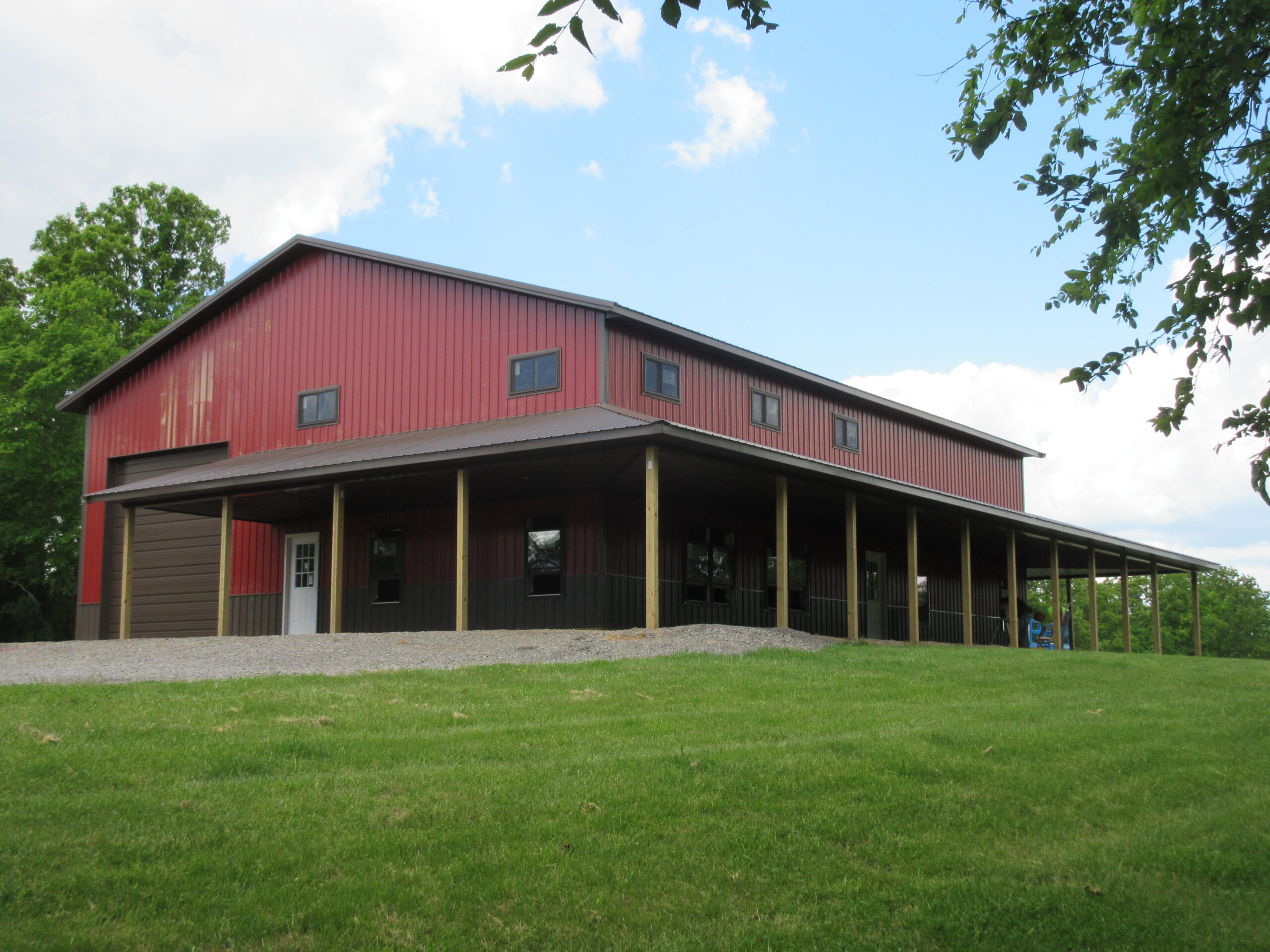 Red and black barn style home with wrap around porch in Marion, Illinois